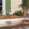 Terrassentisch aus Vollholz mit Essen und Getränken gedeckt